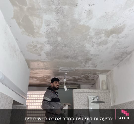 אדם צובע תקרה עם שפכטל וחומר מילוי